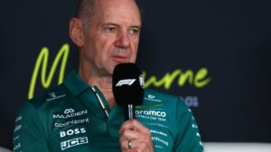 Adrian Newey i Aston Martins gröna teamkläder talar i mikrofon under en presskonferens i Formel 1.