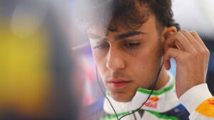 Arvid Lindblad adjusts his earpiece in the Racing Bulls garage during the qualifying weekend for the Belgian Grand Prix at Spa-Francorchamps.