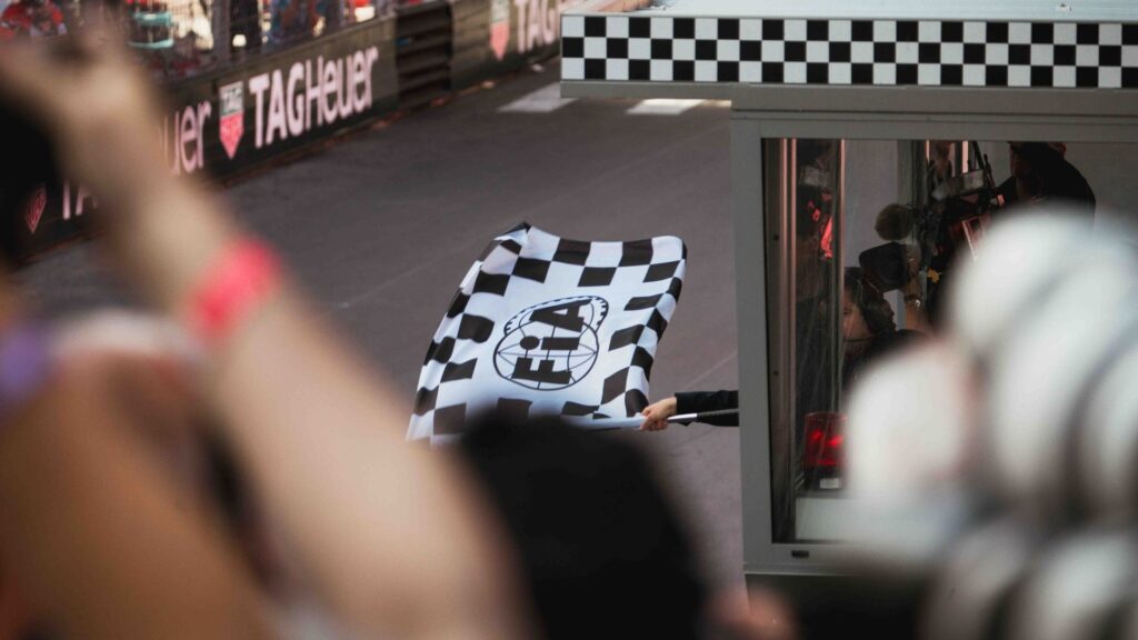 En funktionär vinkar målflaggan under ett Formel 1-lopp